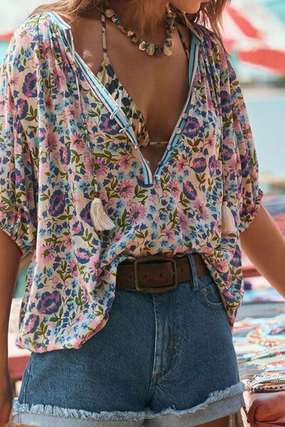 Floral tie neck half sleeve blouse with vibrant pattern and denim shorts.