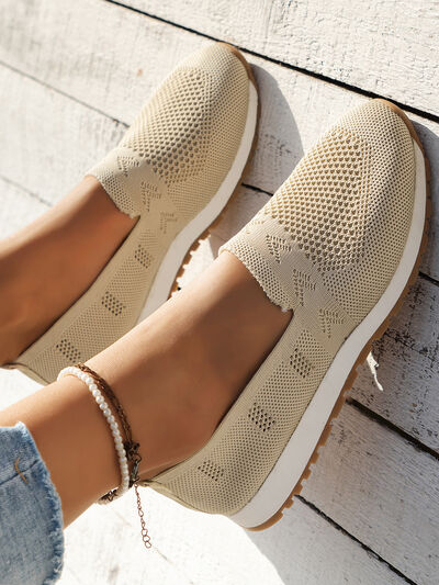 Mesh round toe flat slip-ons in beige, made of rubber and mesh material, worn on feet.