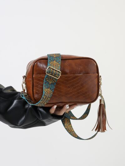 Tassel PU leather cassette crossbody bag with printed strap.