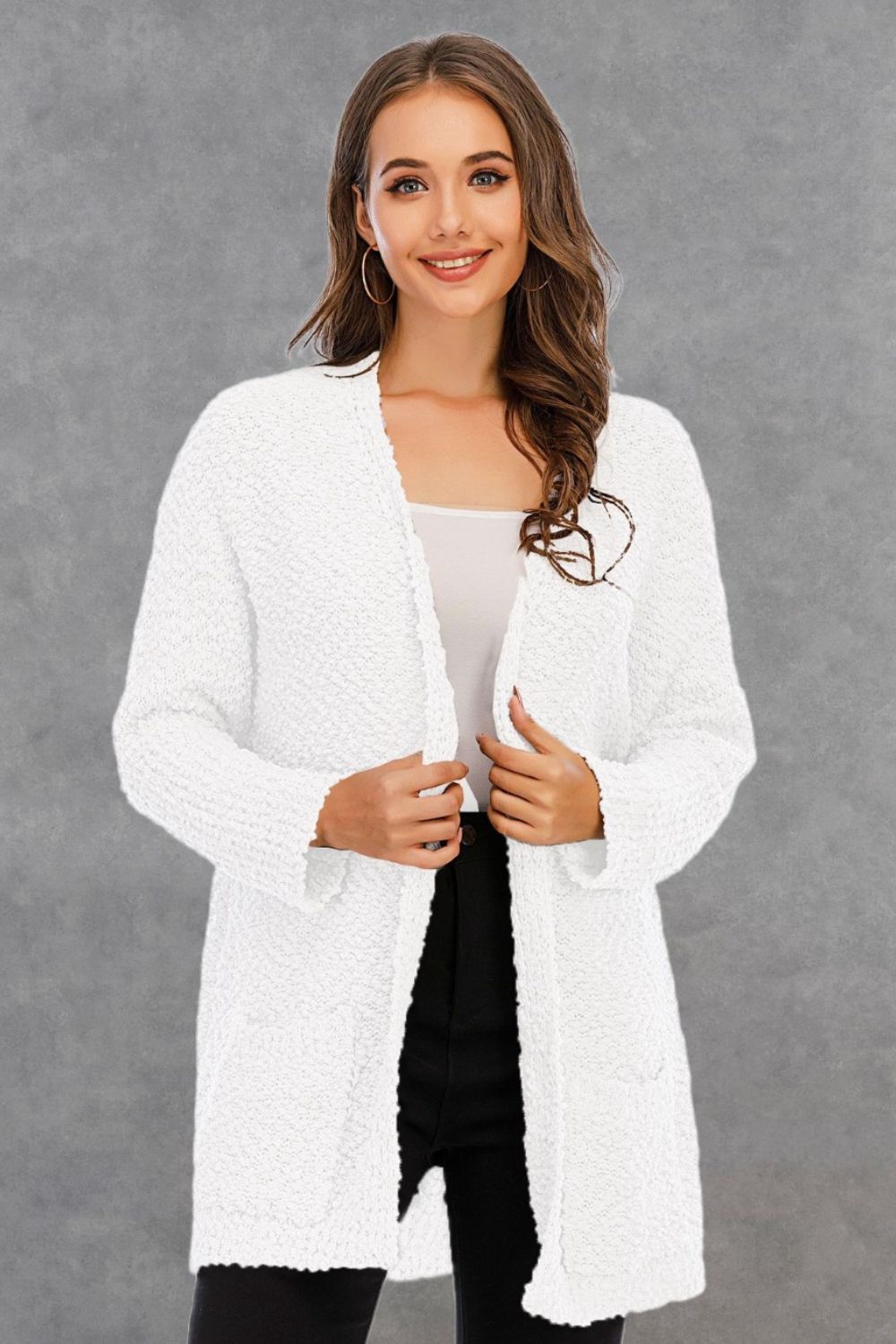 Pocketed open front long sleeve white cardigan made of polyester with moderate stretch.