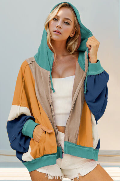 Double Take Full Size Color Block Zip Up Hoodie with pockets and drawstring, featuring exposed seams and slightly stretchy material.