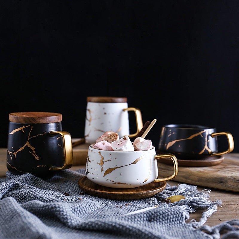 Coffee mugs with marble gold inlay and wooden handles on a table setting.