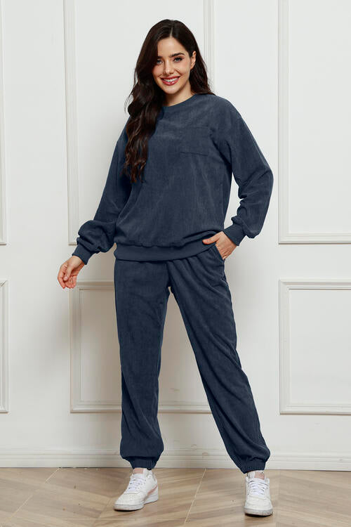 Round neck sweatshirt and sweatpants set in navy, two-piece, slightly stretchy fabric.